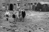 Young lads walk over a bomb site.jpg